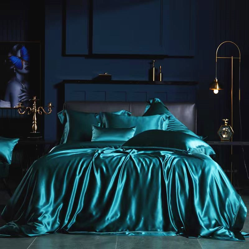 a luxurious bedroom with a large bed dressed in a satin bedspread in a deep blue color. The bed is adorned with matching pillows and a matching comforter, creating a harmonious and elegant atmosphere. The room is dimly lit, with a chandelier providing a warm glow, and a painting hanging on the wall adding an artistic touch to the space.