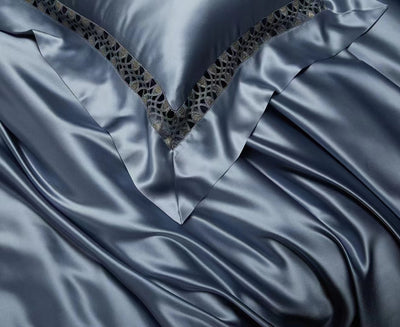 a close-up view of a fabric with a metallic, metallic-looking texture. The fabric appears to be made of a shiny material, possibly silk or satin, and has a metallic-looking pattern on it. The fabric is folded and crumpled, giving it a textured and wrinkled appearance.